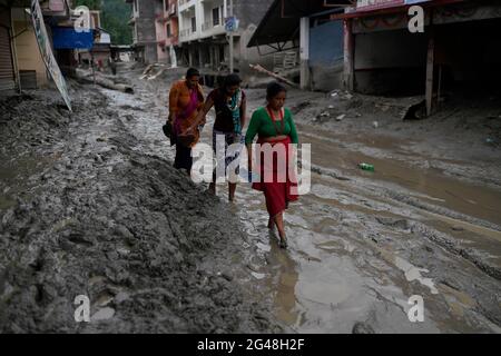 Helambu, Népal. 19 juin 2021. Les gens marchent le long de la route boueuse après que les inondations aient fait des ravages dans la municipalité rurale de Helambu, au Népal. Selon les médias, au moins 23 personnes sont toujours portées disparues dans les glissements de terrain de la région de Bhemathang et les inondations qui ont suivi dans la rivière Melamchi et environ 200 familles ont été déplacées par l'inondation, tandis que plus de 1,000 familles ont été déplacées dans des endroits plus sûrs afin de minimiser les pertes et les dommages supplémentaires causé. Crédit: Skanda Gautam/ZUMA Wire/Alay Live News Banque D'Images