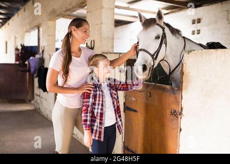 Des sœurs souriantes qui couronnaient le cheval Banque D'Images