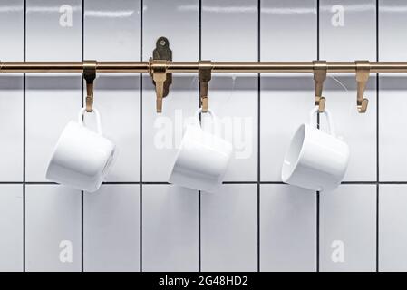 Ensemble de tasses blanches pour le thé sur fond de carreaux de céramique blanc. Banque D'Images