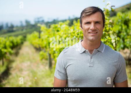 Portrait d'un vigneron souriant debout dans un vignoble Banque D'Images