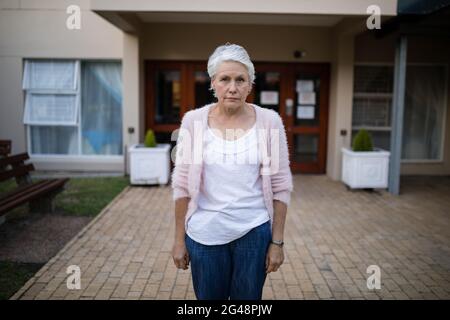Portrait d'une femme âgée sérieuse debout à l'entrée Banque D'Images
