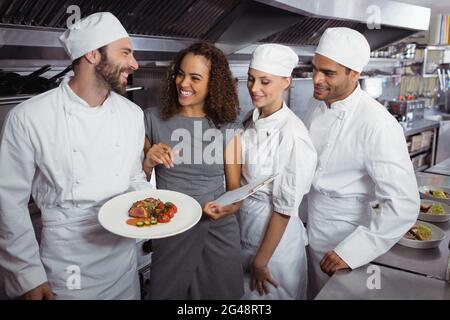 Le directeur du restaurant interagit avec son personnel de cuisine Banque D'Images