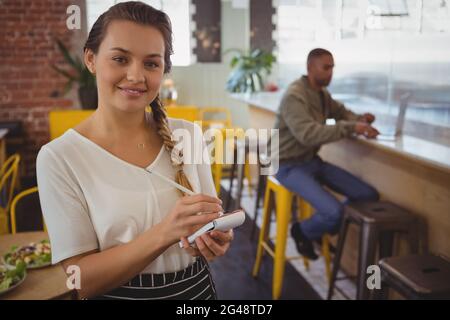 Portrait de serveuse prenant l'ordre par homme d'affaires Banque D'Images