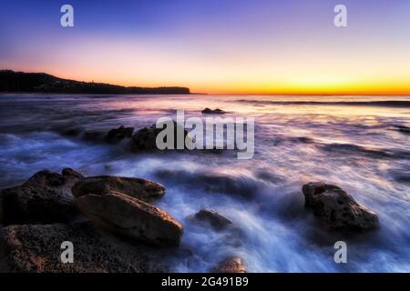 Rochers en grès sur les plages du nord de Sydney Plage de Newport face à l'océan Pacifique et soleil levant. Banque D'Images