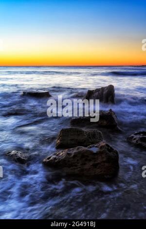 Rochers de grès sur la côte océanique du Pacifique de Sydney - plages du nord de Newport au lever du soleil. Banque D'Images