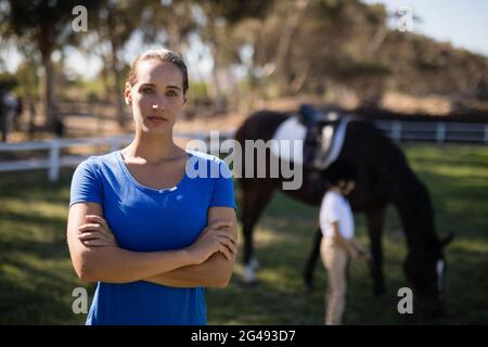 Portrait de jeune femme jockey avec soeur par cheval en arrière-plan Banque D'Images