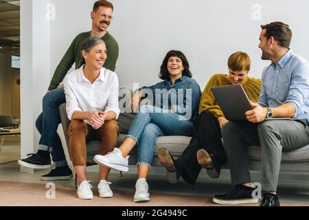 Collègues de bureau assis sur le canapé à la réception. équipe d'affaires assise à la réception. Banque D'Images