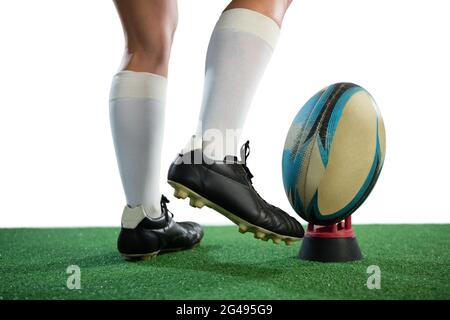 Partie basse du ballon de rugby sportswoman Kicking Banque D'Images