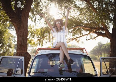 Femme heureuse avec les bras levés sur la camionnette Banque D'Images