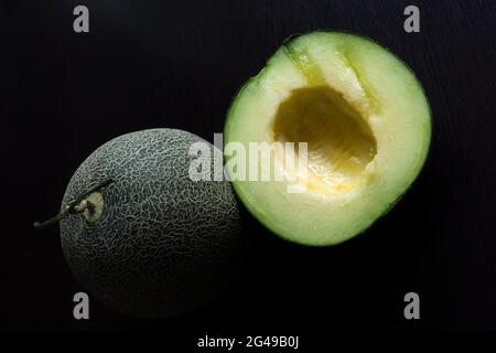 Tranches de melon de cantaloup sur fond noir . Banque D'Images