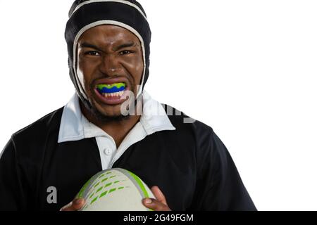 Portrait d'un joueur de rugby masculin portant un protège-dents blanc tenant un ballon de rugby Banque D'Images