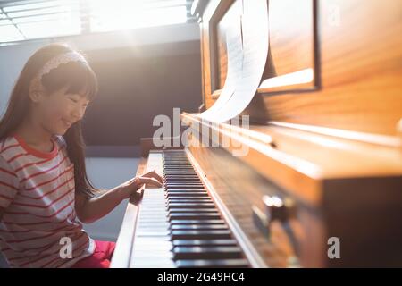 Fille souriante pratiquant le piano en classe Banque D'Images