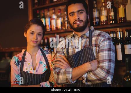 Portrait de serveur et serveuse standing with arms crossed Banque D'Images