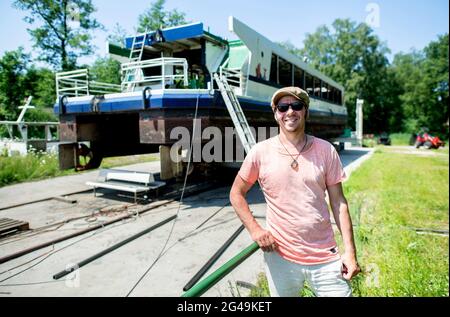 Bad Zwischenahn, Allemagne. 17 juin 2021. Ralf Wiedenhöft, nouveau propriétaire et entrepreneur, se trouve devant le navire à passagers 'S Oldenburg' au Zwischenahner Meer, qui a été scié dans le sens de la longueur. L'ancien navire à passagers doit être transporté par un véhicule lourd de Bad Zwischenahn à Oldenburg. Il sera ensuite utilisé comme navire-restaurant dans le port de la ville. Credit: Hauke-Christian Dittrich/dpa/Alay Live News Banque D'Images