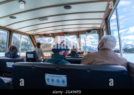 Croisière sur le lac Maligne en été pendant la période pandémique Covid-19. Passagers et guide touristique portant un masque facial à l'intérieur du bateau. Banque D'Images