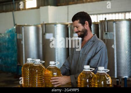 Un employé vérifie une burete d'huile d'olive en usine Banque D'Images