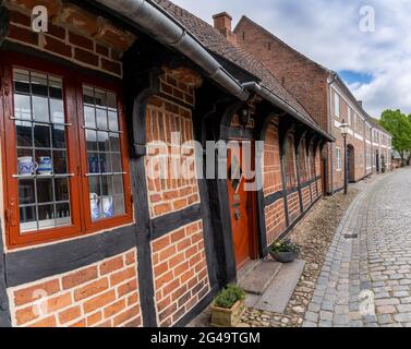 De belles maisons historiques en demi-bois et des cloisons en briques bordent une rue pavée à Ribe Banque D'Images