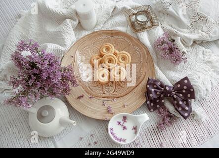 Composition maison avec fleurs de printemps, lait et biscuits au lit. Banque D'Images