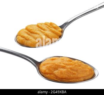 Purée de citrouille et de carottes dans une cuillère isolée sur fond blanc Banque D'Images