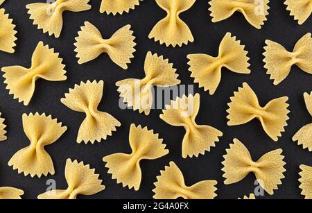 Farfalle Pasta motif sur fond noir, vue du dessus, texture de la pose plate Banque D'Images