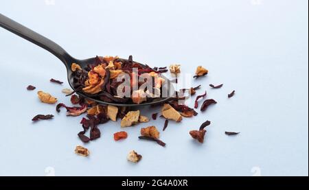 Feuilles de thé aux fruits dans une cuillère sur fond blanc Banque D'Images