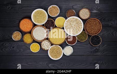 Céréales, céréales, graines et gruaux de fond en bois noir Banque D'Images
