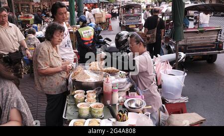 L'argent change de mains vendeurs de nourriture vendeurs de rue dans Chinatown Bangkok Thaïlande Banque D'Images