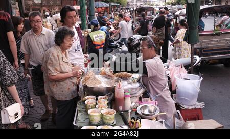 L'argent change de mains vendeurs de nourriture vendeurs de rue dans Chinatown Bangkok Thaïlande Banque D'Images