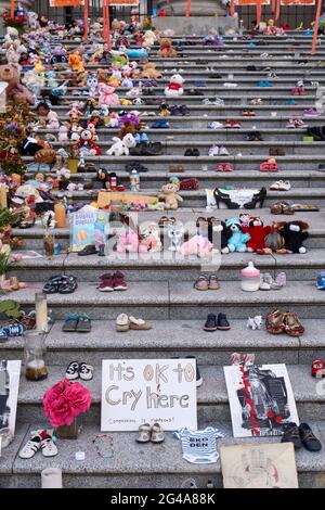 Vancouver, Colombie-Britannique, Canada. 19 juin 2021. L'installation par l'artiste haïda Tamara Bell de 215 paires de chaussures sur les marches de la Vancouver Art Gallery est devenue un sanctuaire de fortune. Cette installation rend hommage aux 215 enfants autochtones dont les tombes non marquées ont été découvertes sur les terrains d'une ancienne école résidentielle de Kamloops, en Colombie-Britannique, au Canada. Banque D'Images