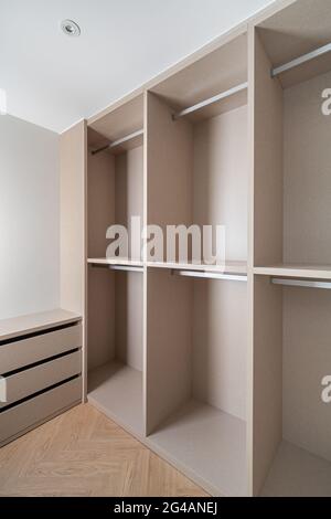 Nouveau mobilier intégré dans un petit dressing. Espace de rangement moderne et vide avec armoire, tiroirs et beaucoup d'espace pour les cintres. Banque D'Images