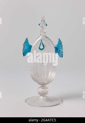 Verre à boire en forme d'instrument à cordes. Pied plat aux bords battus. Tige constituée de nœuds creux nervurés au-dessus d'un disque plat. Corps sous forme d'instrument à cordes. Deux ailes bleues au-dessus du trou bleu de premier cycle. Col légèrement étiré fini dans une tête d'oiseau avec un peigne incolore et une bouche ouverte. Banque D'Images