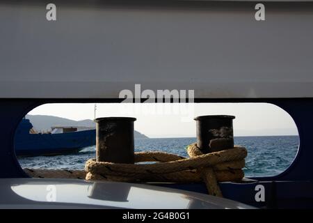 Gros plan des bollards sur un navire avec des cordes attachées sur eux, belle eau calme et navire devant Banque D'Images