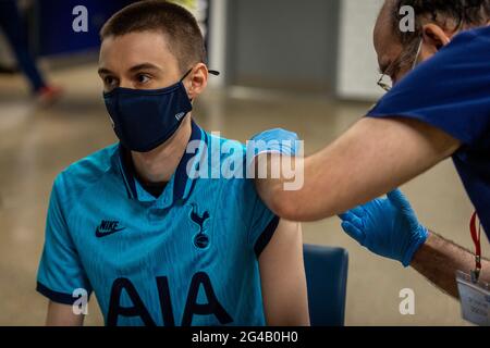 Londres, Royaume-Uni. 20 juin 2021. Richard Walker, 29 ans, fan de Spirs, reçoit un jab vaccinal Pfizer dans un centre de vaccination de masse au stade de Tottenham Hotspur, la capitale ayant pour objectif d'administrer 100,000 doses par jour. Chelsea, West Ham et Charlton étaient d'autres clubs de football de Londres qui ont participé la veille. Crédit : Stephen Chung/Alay Live News Banque D'Images