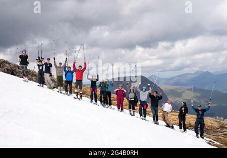 Un groupe d'environ 20 skieurs et snowboardeurs qui ont grimpé jusqu'aux restes de neige sur Meall a'Bhuiridh à Glencoe pour prendre part au ski de milieu d'été. L'événement, organisé par le Glencoe Mountain Resort, se tient chaque année le week-end le plus proche du solstice d'été. Date de la photo: Dimanche 20 juin 2021. Banque D'Images
