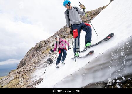 Jemma Clarke et Calum Shepherd, d'Édimbourg, sur l'une des couches de neige restantes sur Meall a'Bhuiridh à Glencoe lorsqu'ils prennent part au ski du milieu de l'été. L'événement, organisé par le Glencoe Mountain Resort, se tient chaque année le week-end le plus proche du solstice d'été. Date de la photo: Dimanche 20 juin 2021. Banque D'Images