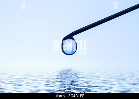 Chute sur la pointe de l'aiguille réfléchie à la surface de l'eau. Photo conceptuelle. Banque D'Images