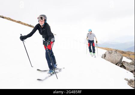 Jemma Clarke et Calum Shepherd, d'Édimbourg, sur l'une des couches de neige restantes sur Meall a'Bhuiridh à Glencoe lorsqu'ils prennent part au ski du milieu de l'été. L'événement, organisé par le Glencoe Mountain Resort, se tient chaque année le week-end le plus proche du solstice d'été. Date de la photo: Dimanche 20 juin 2021. Banque D'Images