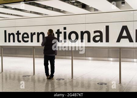 Homme attendant au hall des arrivées internationales pour les voyageurs les clients ont pris l'avion pour l'aéroport de Londres Heathrow, en Angleterre Banque D'Images