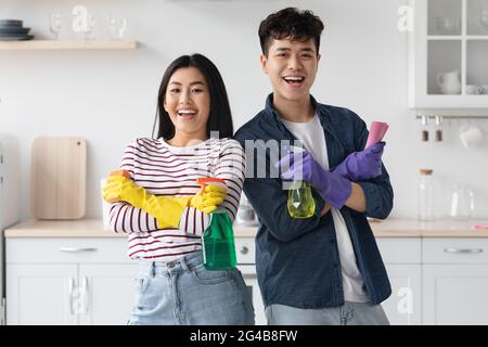 Homme et femme asiatiques heureux gardiens de maison appréciant le nettoyage Banque D'Images