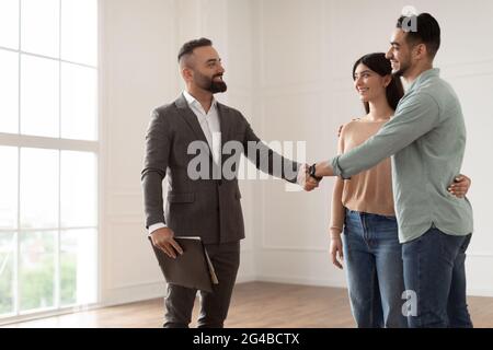 Couple achetant un nouvel appartement, en serrant la main avec Realtor Banque D'Images