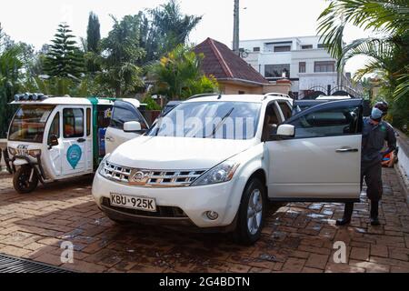 18 juin 2021, Nairobi, comté de Kiambu, Kenya : Un membre du personnel (R) de Wash Me Please Mobile Carwash effectue les derniers retouches d'essuyage d'une voiture à la maison d'un client à Kiambu.The Wash Me Please est une entreprise de démarrage kenyane qui offre des services de lavage de voiture mobile pratiques du confort de votre maison ou de votre lieu de travail comme moyen de Lutte contre la propagation de Covid-19. Wash Me Please est le détail et Carwash Company qui a commencé au début de la pandémie Covid-19. Ils offrent des services mobiles de lavage de voiture aux clients par le biais d'une application mobile que les clients utilisent pour demander leur service. Ce service a offert un Banque D'Images