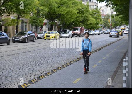 Sofia, Bulgarie - Mai 20 2021: Un petit garçon sur un scooter dans la piste cyclable sur le boulevard Dondukov Banque D'Images