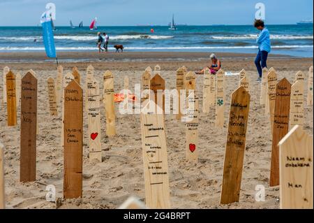 La Haye, pays-Bas. 20 juin 2021. Le jour de la Journée mondiale des réfugiés, les gens de toute l'Europe commémorent les 44.000 victimes qui sont mortes aux frontières européennes au cours des dernières années. Sur la plage de Scheveningen, à la Haye, un monument commémoratif a été placé près de la mer pour payer le dernier respect aux victimes. Le monument commémoratif se composait de 44.000 panneaux commémoratifs en bois sortant du sable sur la plage avec les noms des victimes écrits sur eux. Crédit : SOPA Images Limited/Alamy Live News Banque D'Images