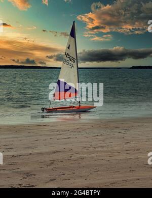 Un dériveur en bord de mer après une journée de plaisir à la voile. Photographie prise sur la plage d'Embleton Bay, Northumberland. Banque D'Images