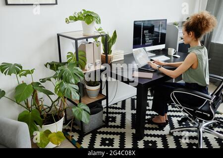 Programmeur assis sur son lieu de travail et travaillant avec le logiciel sur un ordinateur portable Banque D'Images