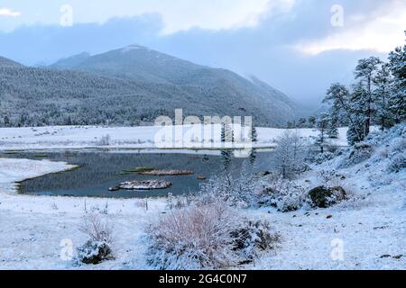 Neige printanière à Sheep Lakes - le soir, la lumière du soleil se couche à travers des nuages épais sur la neige entourée de Sheep Lakes, parc national des montagnes Rocheuses, Colorado, États-Unis. Banque D'Images