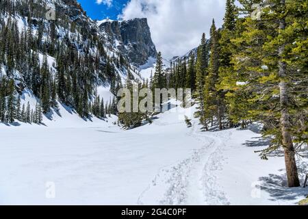 Snow Trail - UN sentier de randonnée dans la neige qui s'enroule le long du lac Dream en efferveuse vers l'imposant sommet de Hallett. Parc national de Rocky Mountain, Colorado, États-Unis. Banque D'Images