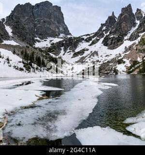 Emerald Lake - VUE de printemps à grand angle sur le lac Emerald à moitié gelé, au pied du pic de Hallett et des flèches sauvages de Flattop Mountain. RPNP. Banque D'Images