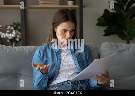 Une jeune femme malheureuse se sent inquiète de lire les nouvelles. Banque D'Images