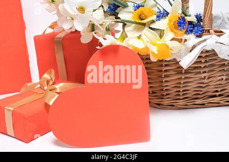Belle carte de voeux avec coeur, cadeaux et un panier de fleurs de jonquilles. Bonne fête des mères, jour de la famille, anniversaire, anniversaire avec un lieu de texte Banque D'Images